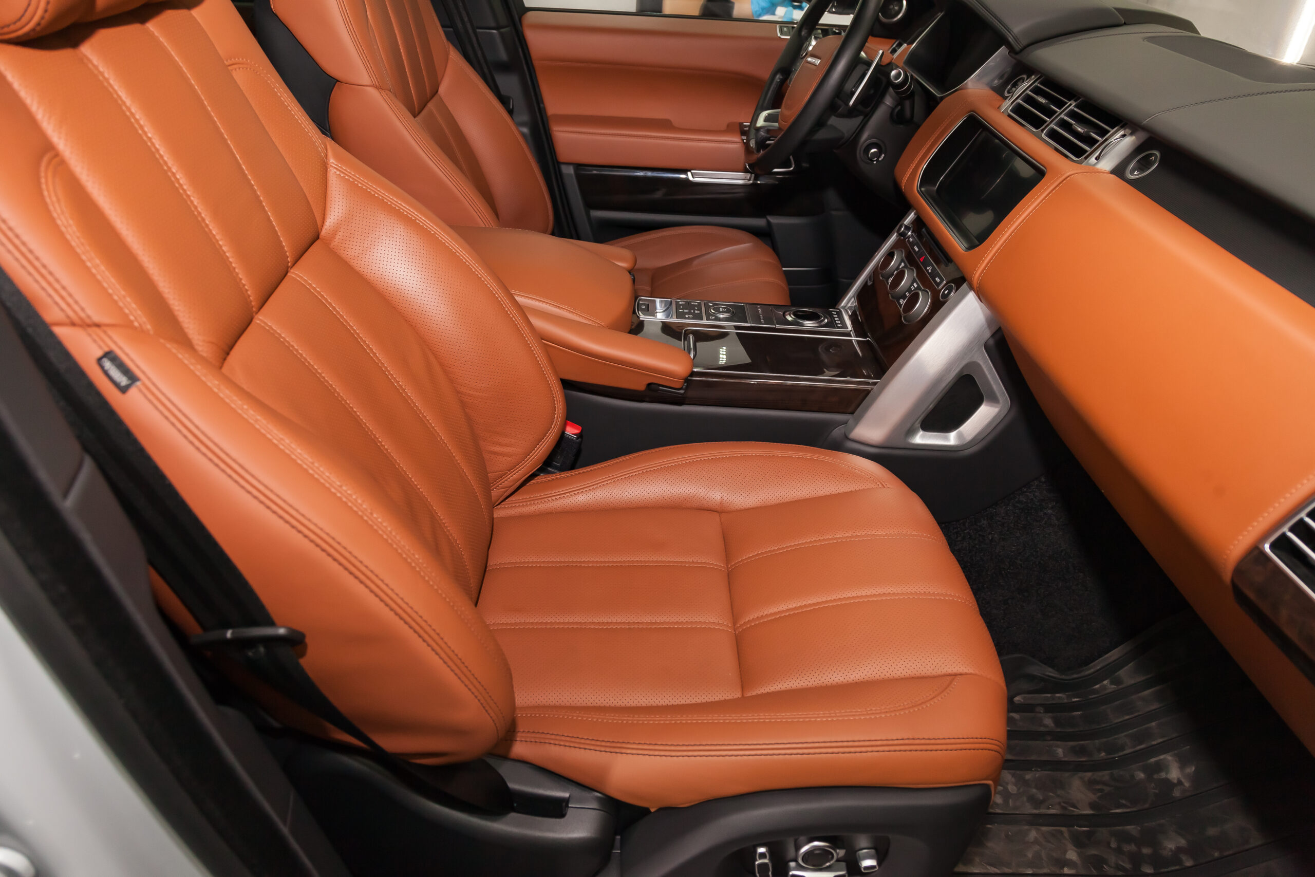 Novosibirsk, Russia - 08.01.2018: View to the white  interior of Land Rover Range Rover with dashboard, clock, media system, front seats and brown leather after cleaning before sale on parking